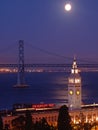 The moon above Ferry Building & Bay Bridge Royalty Free Stock Photo