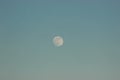 The moon against the blue sky and next to the plane flies. it was getting dark, the sunset and the moonrise. day and night change