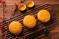 Moon cake Mooncake table setting - Round shaped Chinese traditional pastry with tea cups on wooden background, Mid-Autumn Festival