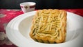 Moon cakes with Red Bean served with tea, on red gold velvet with a magnolia flower pattern background. Royalty Free Stock Photo