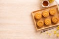 Moon cakes with tea on bright wooden table, holiday concept of Mid-Autumn festival traditional food layout design, top view, flat