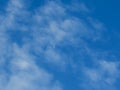 Moon during day in the blue sky between clouds.