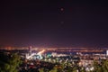 Moon eclipse. View of the night city of Saratov, Russia. The lights of a metropolis in the night.