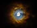 Moon, almost full, shining through clouds creating a vibrant and colorful halo. Natural phenomenon. Beautiful and scenic skyscape