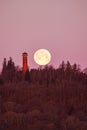 Moon going down by a tower in a the forest at sunrise Royalty Free Stock Photo