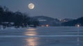 The moon hangs low in the night sky its pale light dancing across a frozen lake and creating an otherworldly atmosphere Royalty Free Stock Photo