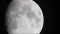 Moon moving large clouds craters in dark night sky.