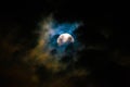 Moon at night covered by clouds carried by the wind.