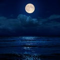 moon in night over clouds and sea with reflections Royalty Free Stock Photo