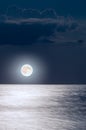 Moon at night in the sky with clouds over the sea Royalty Free Stock Photo