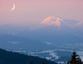 Moon over snow-covered peak