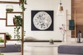 Moon painting above tatami mat bed in japanese style flat interior with ivy on wooden rack and ladder near the window. Real photo Royalty Free Stock Photo