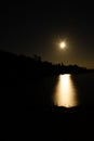 Moon path on a black night oncalm water of Lake Ladoga among rocks in Karelia Royalty Free Stock Photo