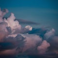 Moon peeks through billowing clouds, creating a mystical ambiance