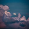 Moon peeks through billowing clouds, creating a mystical ambiance