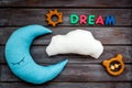 Moon pillow, clouds, dream copy and toys for put baby in bed on wooden background top view