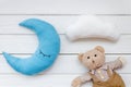 Moon pillow, clouds and teddy bear for put newborn in bed on white wooden background top view Royalty Free Stock Photo