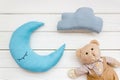 Moon pillow, clouds and teddy bear for put newborn in bed on white wooden background top view Royalty Free Stock Photo