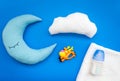 Moon pillow, clouds and toys for put baby in bed on blue background top view