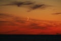 Moon and red clouds after sunset Royalty Free Stock Photo