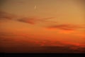 Moon and red clouds after sunset Royalty Free Stock Photo