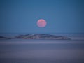 The moon rise from the horizon shortly after sunset