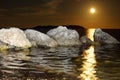 Moon rise reflecting on the water with rocks and island Royalty Free Stock Photo