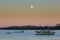 A full moon rising above boats in a harbor Royalty Free Stock Photo