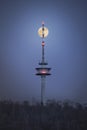 Moon Rising Above a Telecommunication Tower at Night Royalty Free Stock Photo