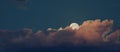 Moon rising behind an orange cloud bank Royalty Free Stock Photo