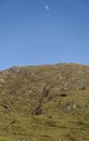 The Moon Rising in a blue Sky over a Rugged Hill in the North Lochs area of the Isle of Lewis Royalty Free Stock Photo