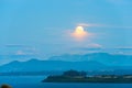 Moon rising between the clouds over Lake Llanquihue Royalty Free Stock Photo