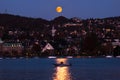 Moon rising over the hills on Zurich Switzerland lakeside point of view late evening