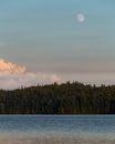 Moon Rising Over Pink Clouds Green Forest and Lake Sunset Royalty Free Stock Photo