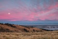 Moon seen on pink sunrise over city Royalty Free Stock Photo