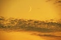 Moon set in orange sky observing and clouds after sunset Royalty Free Stock Photo