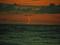 Red moon set over sea observing and clouds after sunset Royalty Free Stock Photo