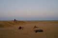 Moon set. View of Thar desert sand dunes , pre dawn light before sun rise and moon setting off in the sky. Rajasthan, India