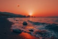 the moon is setting over the ocean in front of rocks Royalty Free Stock Photo