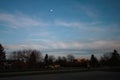 Sunset moon over neighborhood trees