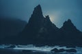 the moon is shining through the foggy night sky over a rocky beach Royalty Free Stock Photo