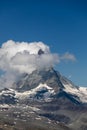 Moon shining over the famous matterhorn with clouds and blue sky