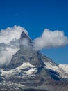 Moon shining over the famous matterhorn with clouds and blue sky