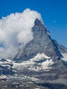 Moon shining over the famous matterhorn with clouds and blue sky