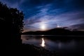 The Moon shinning through the clouds as it rises over the Hills by Ullswater