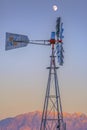 Moon in sky above windmill in front of mountains Royalty Free Stock Photo