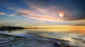 Moon on sky at pink sunset sea water blue reflection and seashell on beach stone nature landscape background Royalty Free Stock Photo