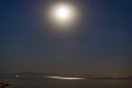 Moon and stars in the night sky and reflections in the sea Royalty Free Stock Photo