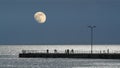 Moon at sunset in the evening over the sea dock