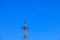 The moon and the TV tower on a clear blue sky day Royalty Free Stock Photo